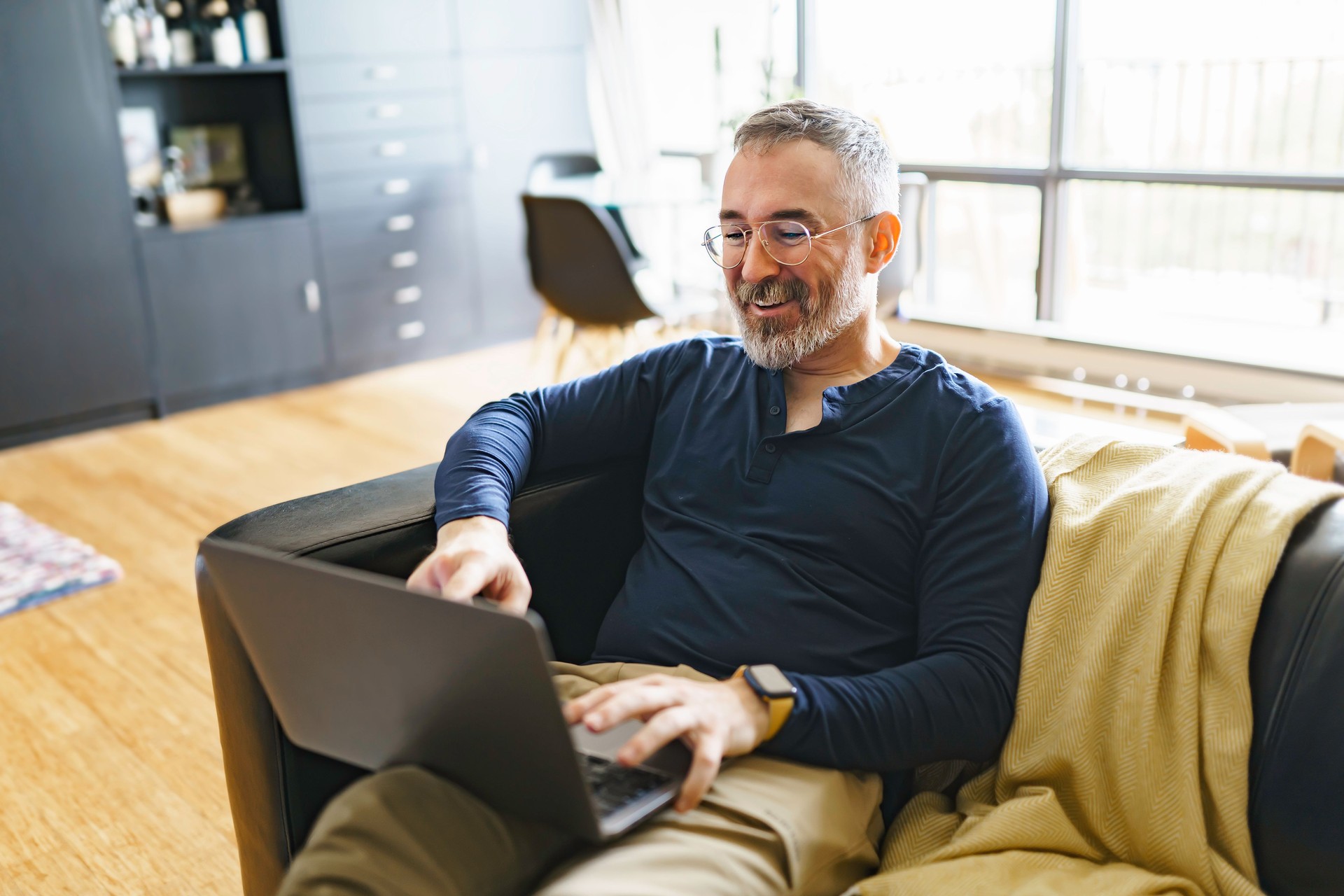 Portrait of handsome man with laptop on sofa