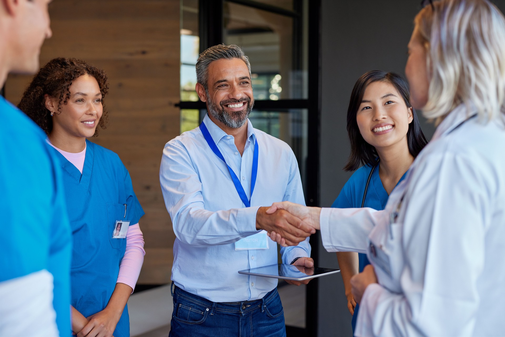 Mature woman doctor shaking hands with pharmaceutical representative at hospital